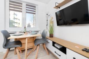 a dining room with a table and chairs and a tv at Apartament Przystań Gdynia by Renters in Gdynia