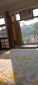 una camera da letto con un letto e una finestra con vista di Shiv Gauri Home Stay a Rishikesh