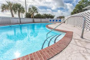 a swimming pool with a metal rail next to a fence at The Waterway Pet Friendly by Carolina Retreats in Wrightsville Beach