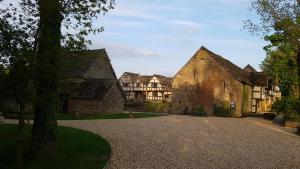 キングトンにあるThe Threshing Barn at Penrhos Courtの大きなレンガ造りの建物と木々のある敷地