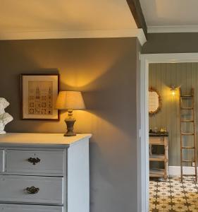 a room with a dresser with a lamp on it at The Threshing Barn at Penrhos Court in Kington