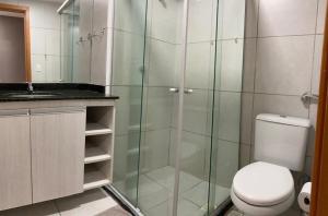 a bathroom with a toilet and a glass shower at Studio Comfort West Flat in Mossoró