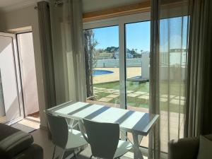 a white table and chairs in a room with a window at Vila Paz in Carvoeiro