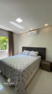 a bedroom with a bed and a window at Residencial Rocha - Praia de Guaratiba - Prado - Ba in Prado +9 photos