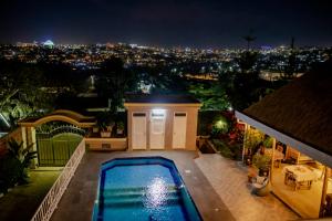 een huis met een zwembad in de nacht bij Villa Asimba in Kigali
