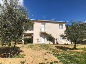 une image d'une villa avec des arbres devant elle dans l'établissement U SOLE, à Ajaccio