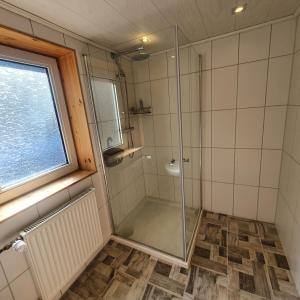 a shower in a bathroom with a glass shower at B&B Waldcafe in Altenau +22 photos