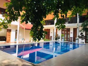 a swimming pool in front of a building at Kingcity Resort in Anuradhapura