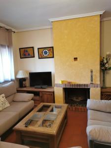 een woonkamer met een bank en een open haard bij La Cerca de Torrecaballeros, a 10 min de Segovia in Torrecaballeros