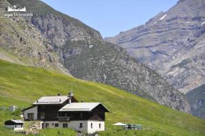 リヴィーニョにあるAppartamenti Green esclusivo riservato soleggiatoの山の横の丘の上の家