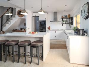a kitchen with white cabinets and bar stools at 3 Bed Villa - Sleeps 6 - Pool - Garden - Parking in Manilva