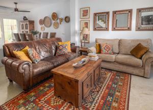a living room with a leather couch and a coffee table at 3 Bed Villa - Sleeps 6 - Pool - Garden - Parking in Manilva +7 photos