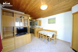 Pokój ze stołem i telewizorem oraz kuchnią w obiekcie Appartamento MilHouse by Livigno Accomodation w Livigno