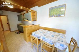 kuchnia i jadalnia ze stołem i krzesłami w obiekcie Appartamento MilHouse by Livigno Accomodation w Livigno