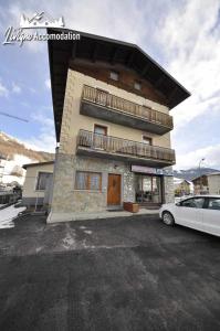 budynek z zaparkowanym przed nim samochodem w obiekcie Appartamento MilHouse by Livigno Accomodation w Livigno