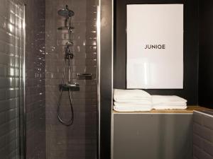 a bathroom with a shower and some towels on a shelf at P182 Hidden Hostel in Berlin
