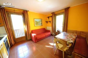 a living room with a red couch and a table at Casa Florin Giumel con vista sulle piste da sci in Livigno