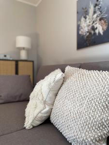 a white pillow sitting on top of a couch at Das Bergquartier - Ferienwohnung Zugspitze in Oberau