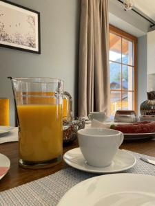 una mesa con un vaso de zumo de naranja y tazones en Das Bergquartier - Ferienwohnung Zugspitze en Oberau