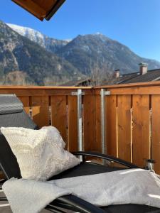 a couch on a balcony with a mountain in the background at Das Bergquartier - Ferienwohnung Zugspitze in Oberau