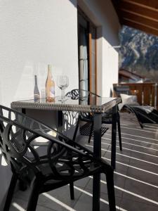 a table with wine bottles and glasses on a balcony at Das Bergquartier - Ferienwohnung Zugspitze in Oberau