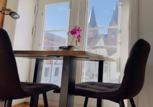 a table with two chairs in front of a window at Ferienwohnung Kleinod in Neuruppin