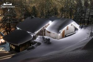 ein schneebedecktes Haus mit Lichtern in der Unterkunft Baita Hanzel e Gretel in Livigno