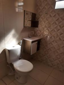 uma casa de banho com um WC branco e um lavatório. em Aluguel Temporada em Martins/RN em Martins