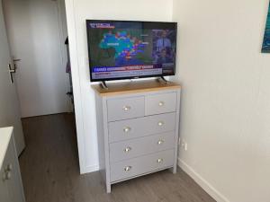 a dresser with a television on top of it at ESCAPADE FAMILIALE A LA MER in Quiberon