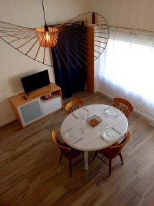 uma sala de jantar com uma mesa branca e cadeiras em Gîte 'Chez Joseph et Cie' -8 mn du Puy du Fou em Les Herbiers