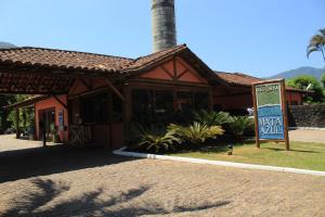 a restaurant with a sign in front of a building at Maresias Beach House - Casas de alugueis em cond beira mar in Maresias