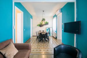 - un salon avec des murs bleus, une table et des chaises dans l'établissement Be barcelona arco del triunfo sunny colors 2, à Barcelone