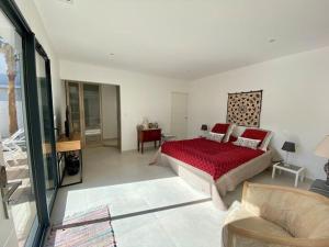 1 dormitorio con cama roja y sala de estar en VILLA D’ARCHITECTE À 400M DE LA PLAGE, en Cap d'Agde