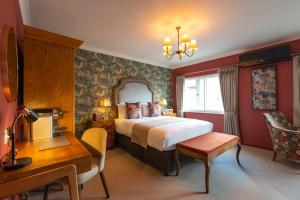 um quarto de hotel com uma cama e uma secretária em The Bear em Bath