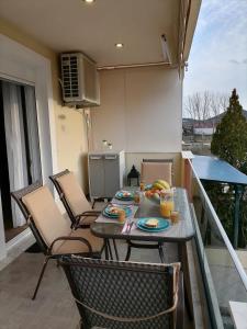 ネア・ペラモスにあるBella Casaのバルコニーにテーブルと食器