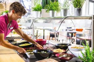 a man preparing food in a kitchen at Belambra Clubs Saint-Jean-de-Monts - Les Grands Espaces in Saint-Jean-de-Monts