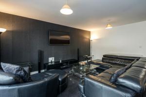 een woonkamer met lederen meubels en een flatscreen-tv bij Beautiful 3-Bed Apartment in Romford in Romford