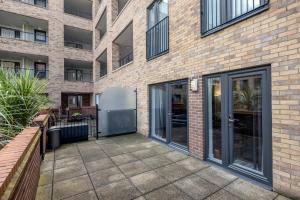 a courtyard in front of a building with glass doors at Beautiful 3-Bed Apartment in Romford in Romford