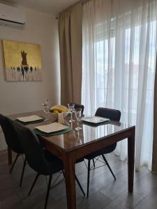 a dining room table with chairs and a table and a window at Explore the Croatian Coast and Relax in Modern Comfort in Kaštela