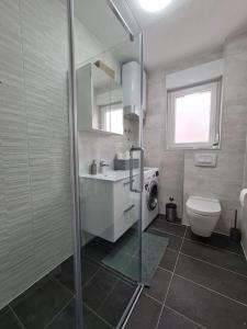 a bathroom with a shower and a sink and a toilet at Explore the Croatian Coast and Relax in Modern Comfort in Kaštela