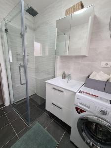 a bathroom with a washing machine and a washer at Explore the Croatian Coast and Relax in Modern Comfort in Kaštela