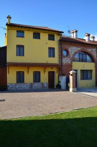 een groot geel huis met een oprit ervoor bij Agriturismo Alla Corte in Vicenza