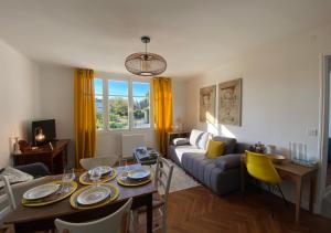un soggiorno con tavolo e divano di Yellow'appart #Moulin#1 -Futuroscope-jardin & parking - La Conciergerie a Jaunay-Clan