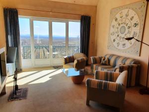 a living room with couches and a large window at Kanzel Residences in Beblenheim