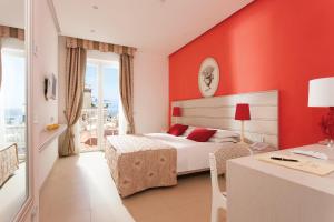 1 dormitorio con cama, mesa y escritorio en Hotel Corallo Sorrento, en Sant'Agnello
