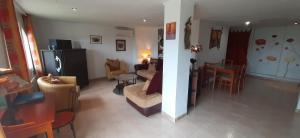 ein Wohnzimmer und eine Küche mit einem Sofa und einem Tisch in der Unterkunft Appartement & Spa - Panoramic Olivars in Pau