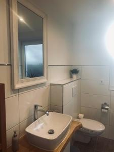 a white bathroom with a sink and a toilet at [E]ifeel like Home in Hauroth