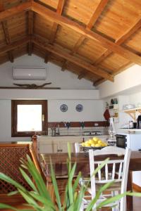 a kitchen with wooden ceilings and a table with fruit on it at Olive Yard House in Skopelos Town