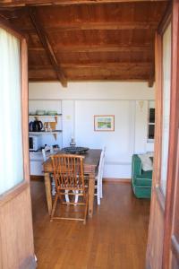 a dining room with a table and chairs and a kitchen at Olive Yard House in Skopelos Town