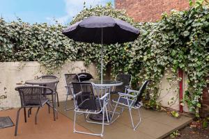 einen Tisch und Stühle mit Sonnenschirm auf einer Terrasse in der Unterkunft Fabulous Stay - 4 Bedroom House, sleeps 9, ideal for Business and Contractors, Free parking in Stoke on Trent